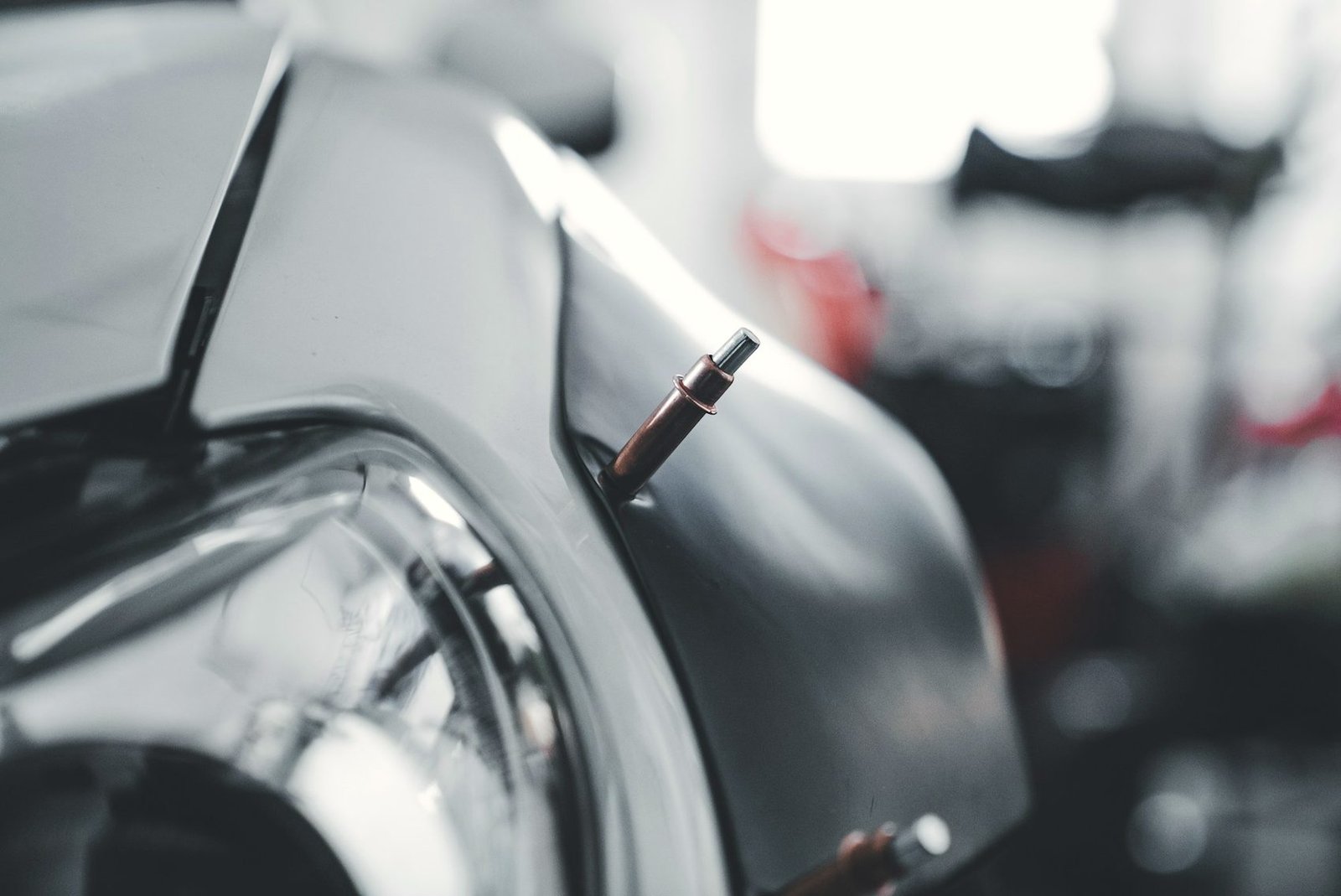 Close view of a spot welder tip against a bare car fender